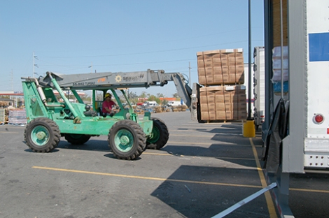 New Orleans, September 7, 2005 - A forklift operator removes two pallets of drinking water from the cargo bay of one of the 20 tractor-trailer units filled with supplies for distribution to individuals at a center set up on Airline Highway. Each unit comntained mkore than 25 tons of ice, water or other life-sustaining supplies for those affected by Hurricane Katrina. Photo by Win Henderson / FEMA photo.